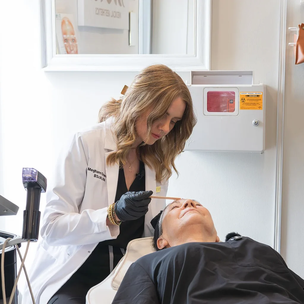 meghann dowding working with a client for a skin care treatment